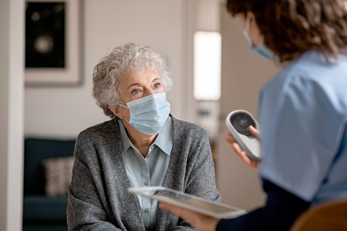 care taker with iPad talking to inhabitant in nursing home.